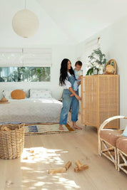 Woman and child in a bedroom with wooden furniture and decor