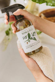 A bottle of Koala Eco Natural Multi-Purposse Kitchen Cleaner held in a woman's hands