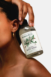 Person holding a bottle of Koala Eco Natural Body Wash against a neutral background