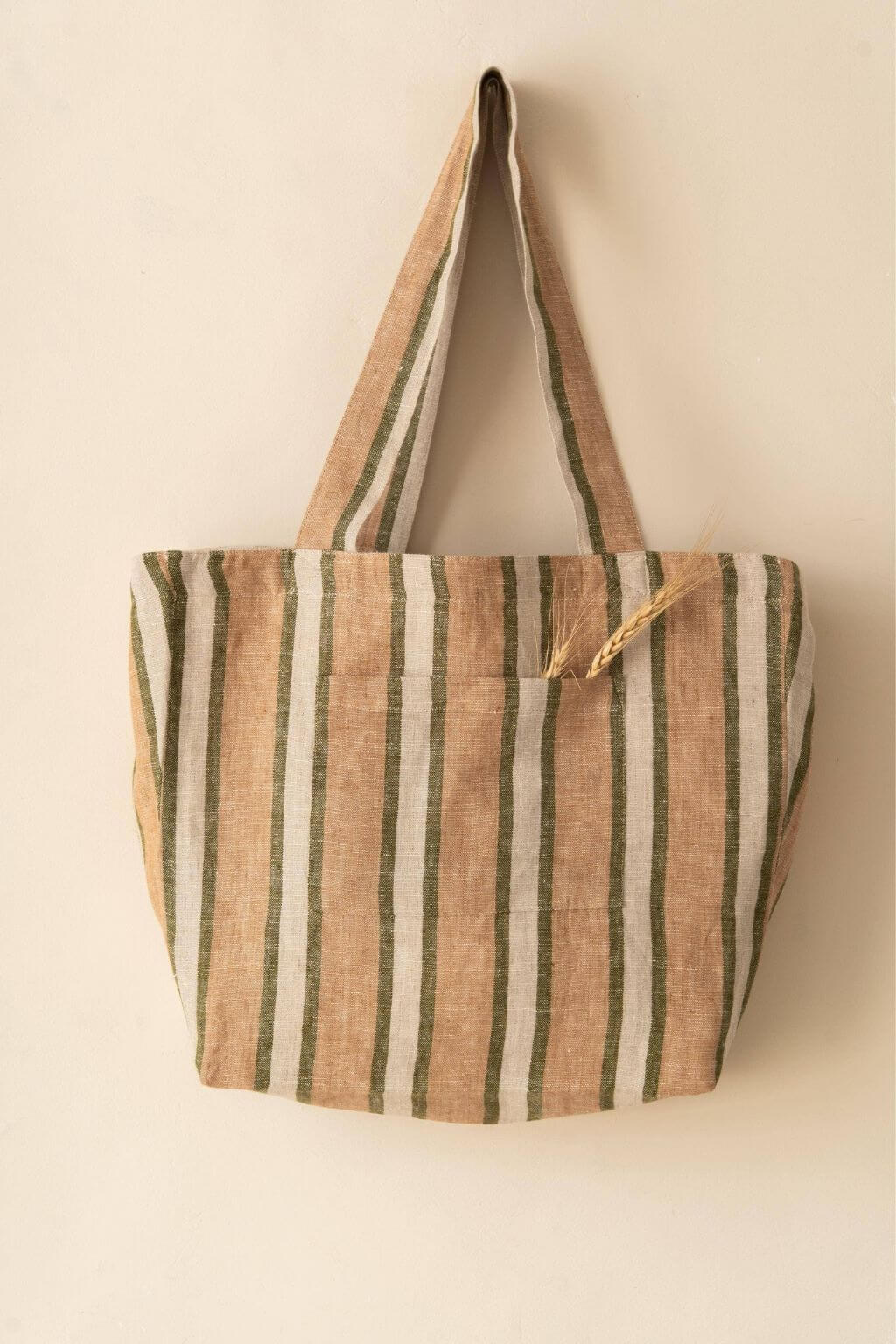 Sylph Striped Linen Market Bag hanging on wall with natural grain poking out of the front pocket