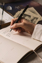 Writing in Magic of I planner during reflective planning ritual