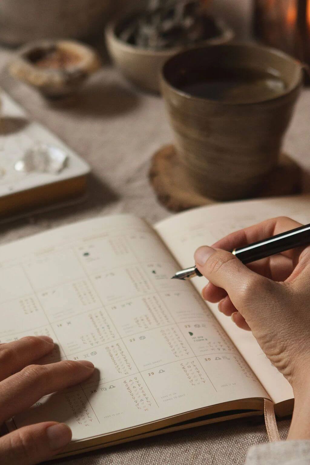 Open planner showing monthly overview with moons and zodiac dates