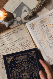 Flat lay of white astrology planner with pen, journal, and ritual objects