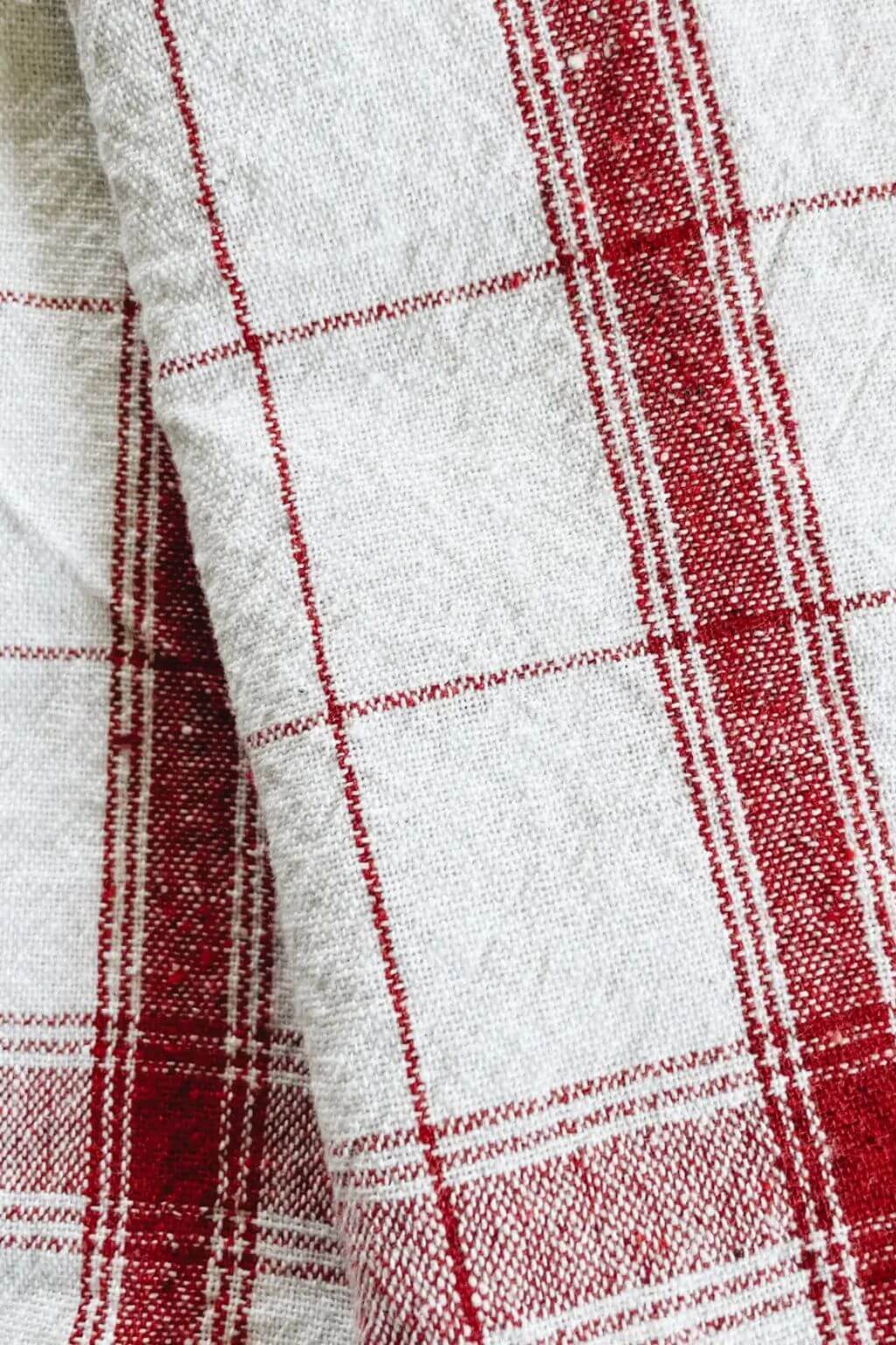 Close-up of handloom French stripe kitchen towel in red and off-white linen.