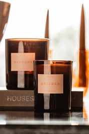 Dresden candle burning on dark reflective surface