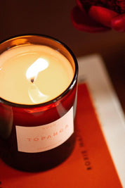 Close-up of lit Topanga candle in amber glass