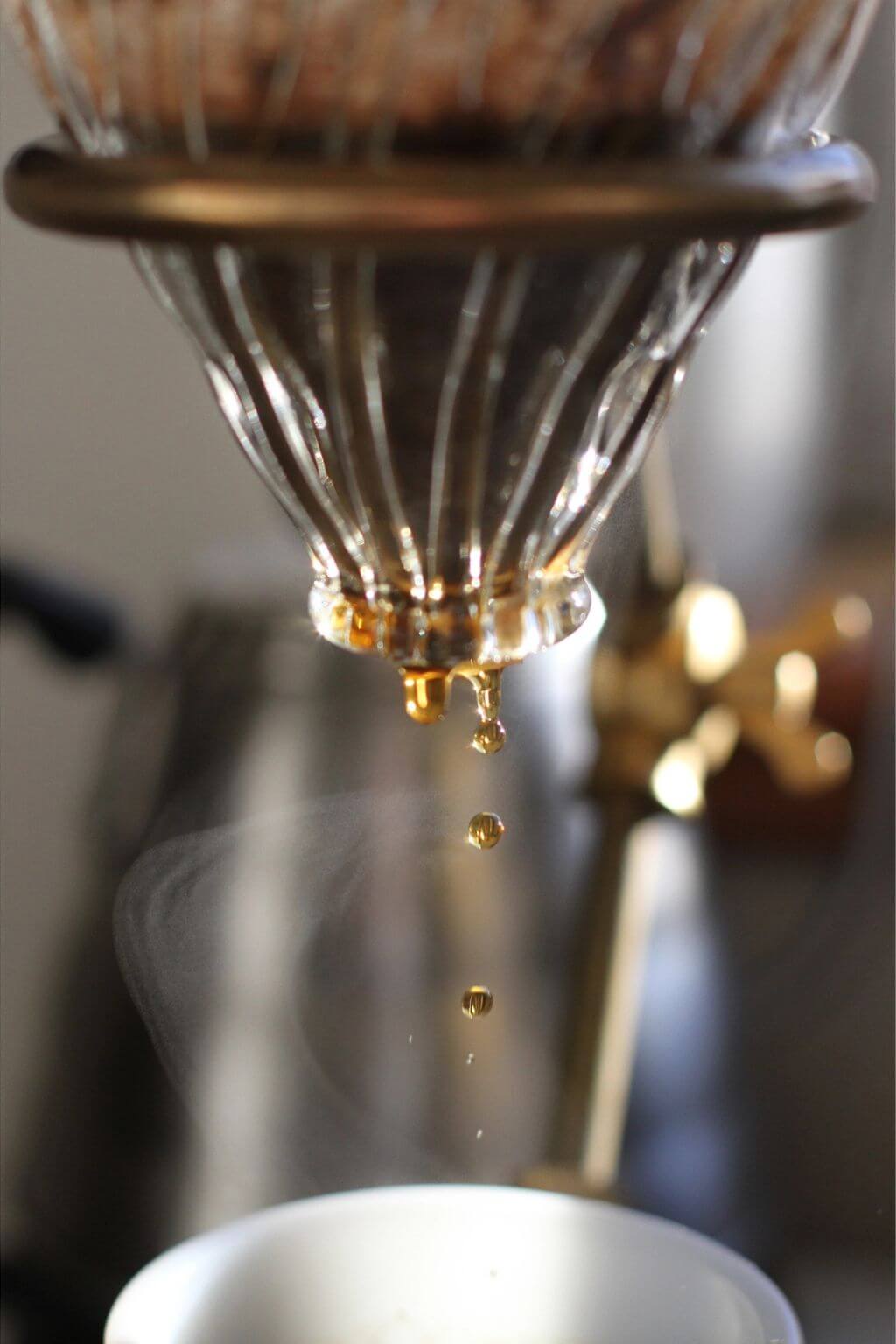 Coffee brewing in progress with The Curator pour-over stand and Hario V60 glass dripper.